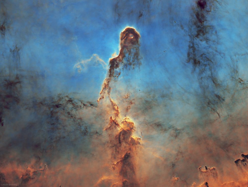 A colourful nebula of gold and brown on a blue background that resembles an elephants head and trunk, some people also suggest it looks like a person walking into the mist. The stars have been removed from this image to show only the nebulousity