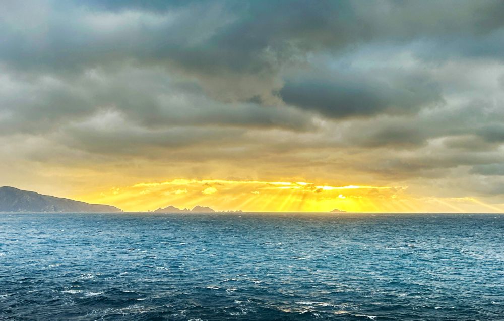 Dark clouds with rays of golden sunshine breaking through.