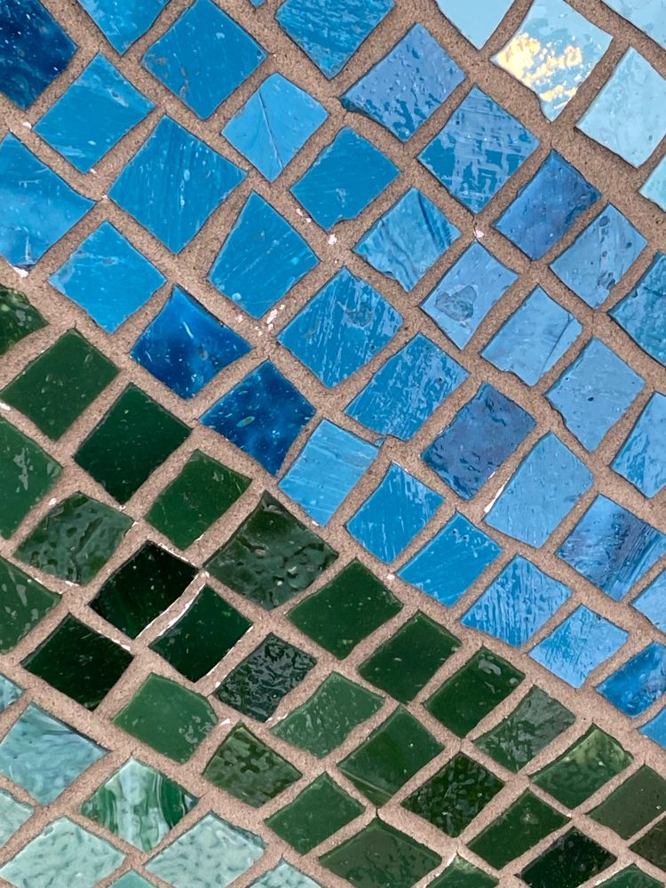 Various shades of blue and green ceramic tiles arranged on a sphere.