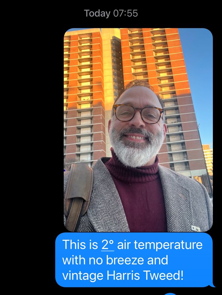 Me wearing a red turtleneck and vintage Harris Tweed jacket with a text that says "This is 2° air temps either with no breeze and a vintage Harris Tweed."