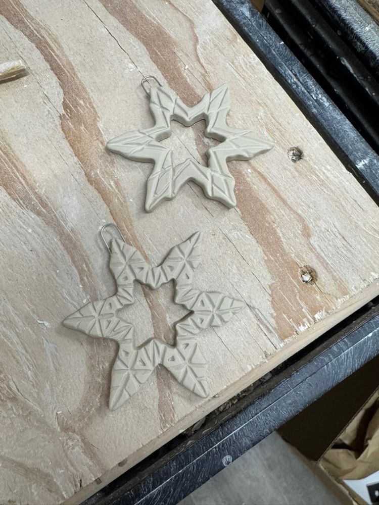 Photo of two porcelain snowflake ornaments.