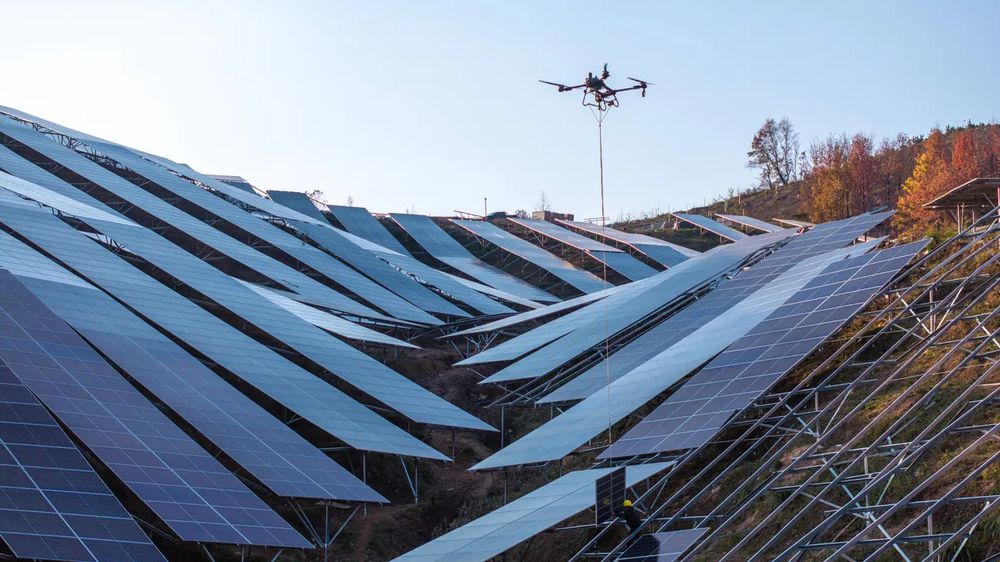 photo of a drone assisting with the construction of a solar farm on a very steep slope