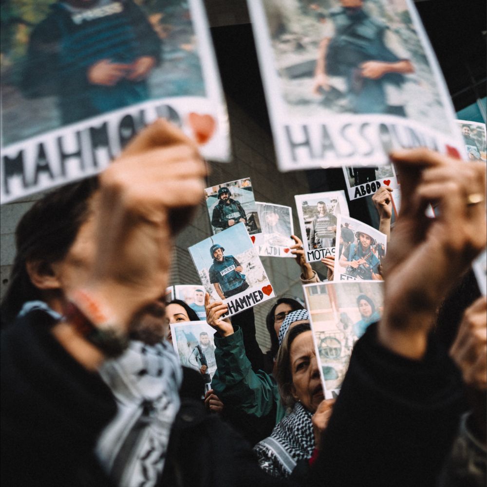 Des manifestants brandissent les portraits de journalistes palestiniens.