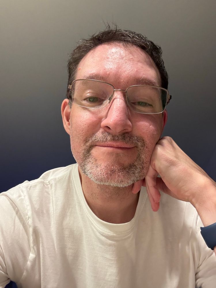 Selfie wearing a white T-shirt leaning on my hand