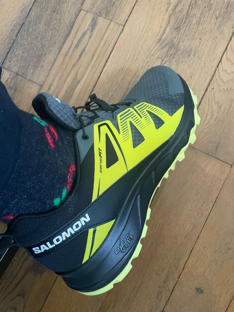 Une paire de Salomon Superz Trail noires, grises et jaunes, achetées avec le doute qu’elles soient moins durables qu’avant le rachat de l’entreprise par une giga compagnie de loisirs chinoise