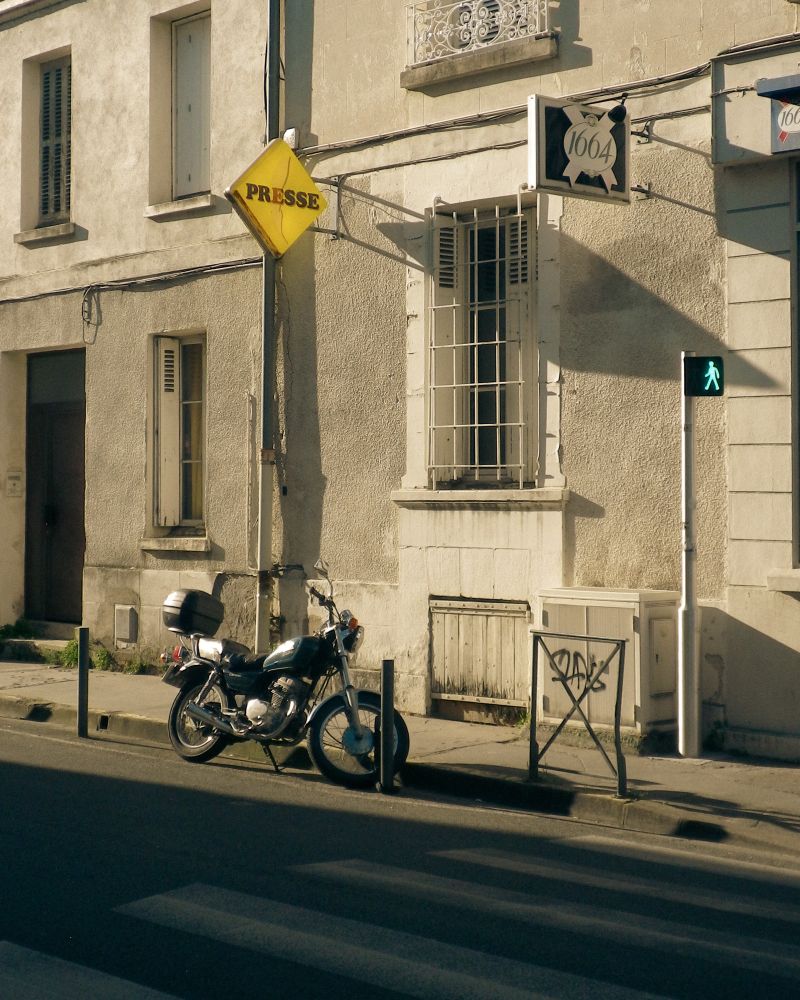 Une moto garée devant un ancien tabac presse