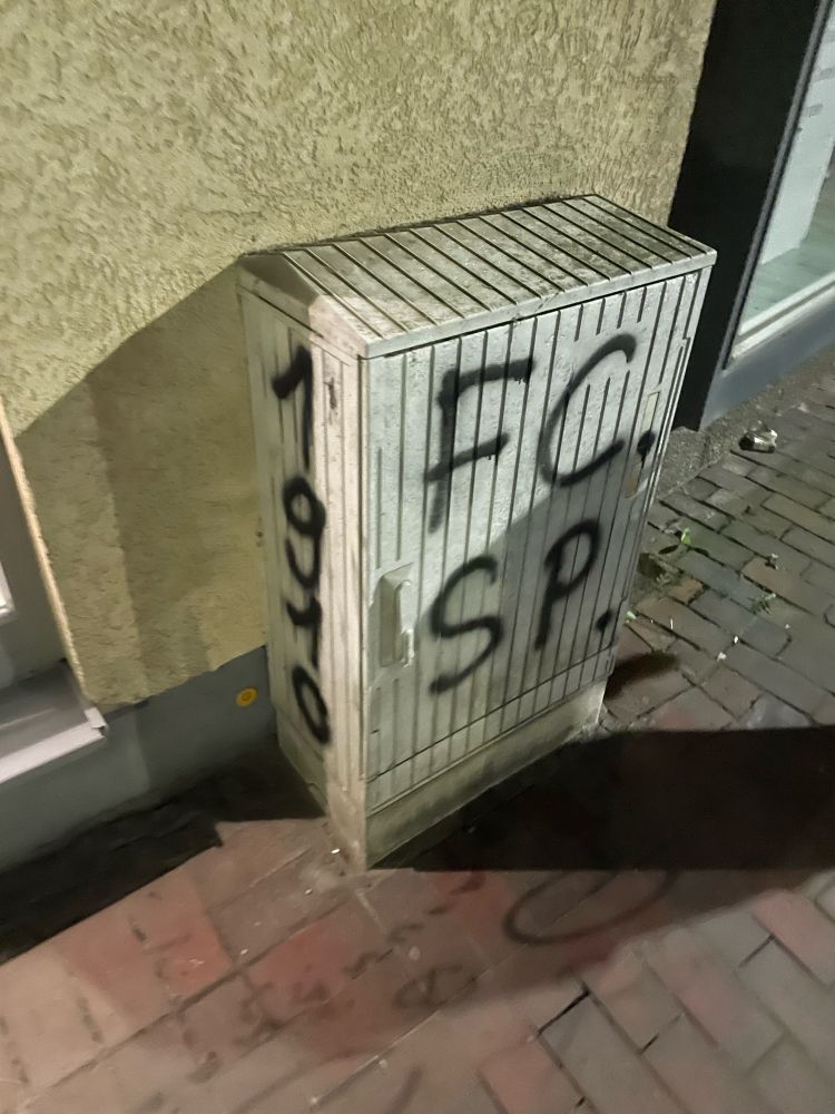 Stromkasten an Hauswand. An der breiten Seite, die zur Straße zeigt ist in schwarz groß FCSP gesprüht. An der linken, schmalen Seite ebenfalls in Schwarz 1910