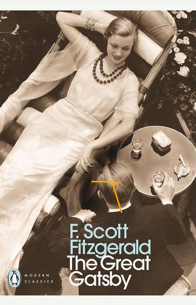 The front cover of The Great Gatsby, a novel by F. Scott Fitzgerald, depicting a black and white, slightly sepia tone, image of a woman in 1920s clothing sitting back in a chair and a man in a dark suit sat with his back to us, leaning into her. He is holding a short glass, presumably of alcohol, on the table between them. Also on the table is an ashtray with two lit cigarettes balanced on the side and a cigarette or tobacco tin.