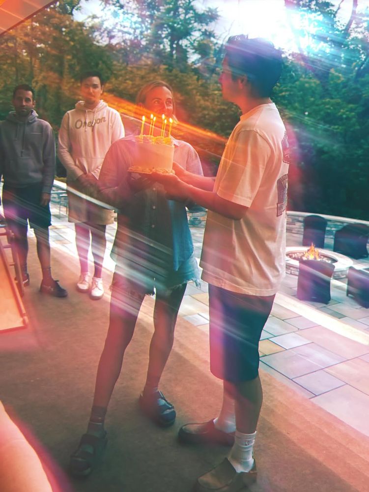 Jenna's birthday. Tyler is holding a cake.