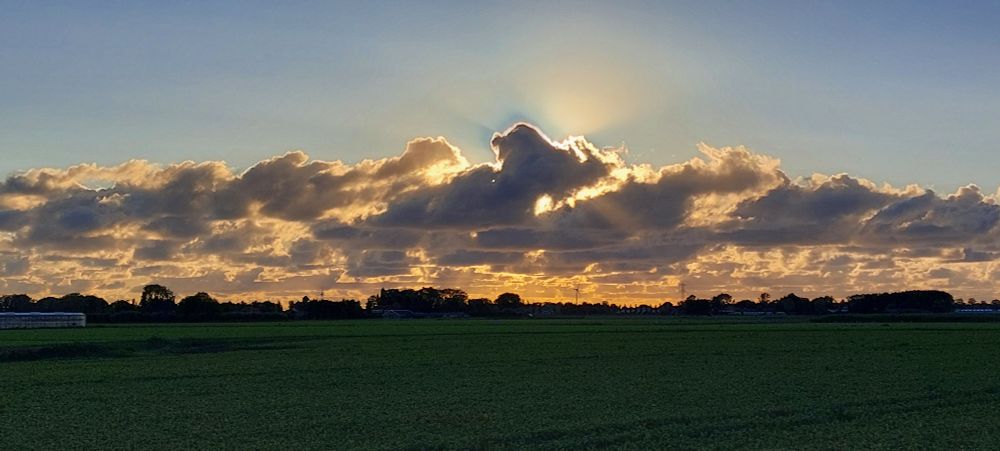 Zon achter wolken wat jakobsladders en sillver lining geeft