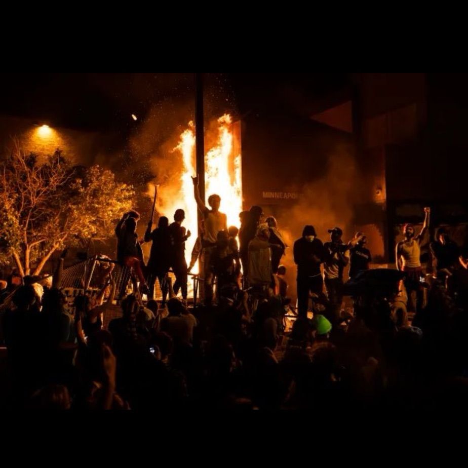 Picture of 3rd precinct burning with people standing in front 