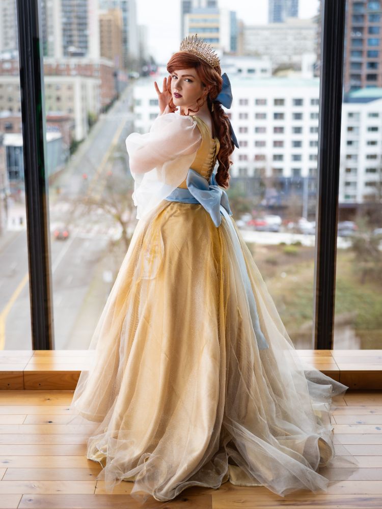 A cosplayer dressed as Anastasia from the 1997 animated movie during the song "Once Upon a December" standing with her back to the camera. 