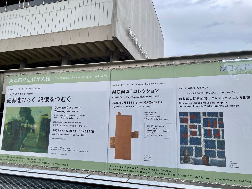 東京国立近代美術館の建物前の看板。『記録をひらく　記憶をつむぐ』展の告知に使われている絵と掲載情報からは、これが戦争記録画展であることは読みとれない。