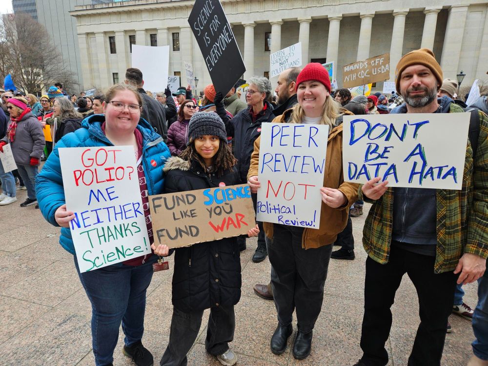 Four of the best lab members one could hope for holding signs at the Stand Up for Science rally in Columbus, Ohio. "Got Polio? Me Neither. Thanks Science", "Fund Science like you fund war" "Peer review, not political review" "Dont be a DATA HATA"