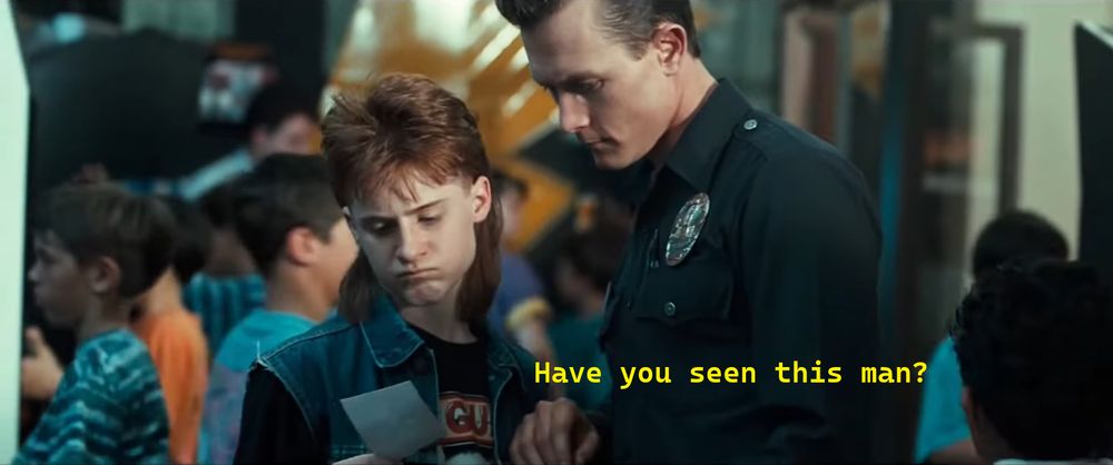 Terminator 2 screenshot. A police officer asks a boy holding a photograph "Have you seen this man?"