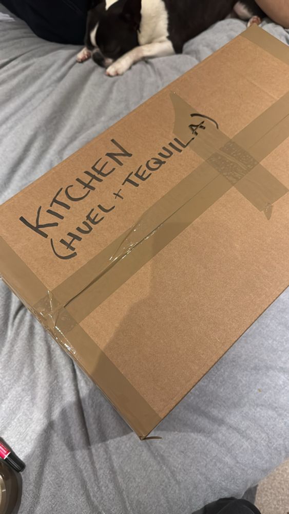 Cardboard box labelled “kitchen (HUEL & tequila)”