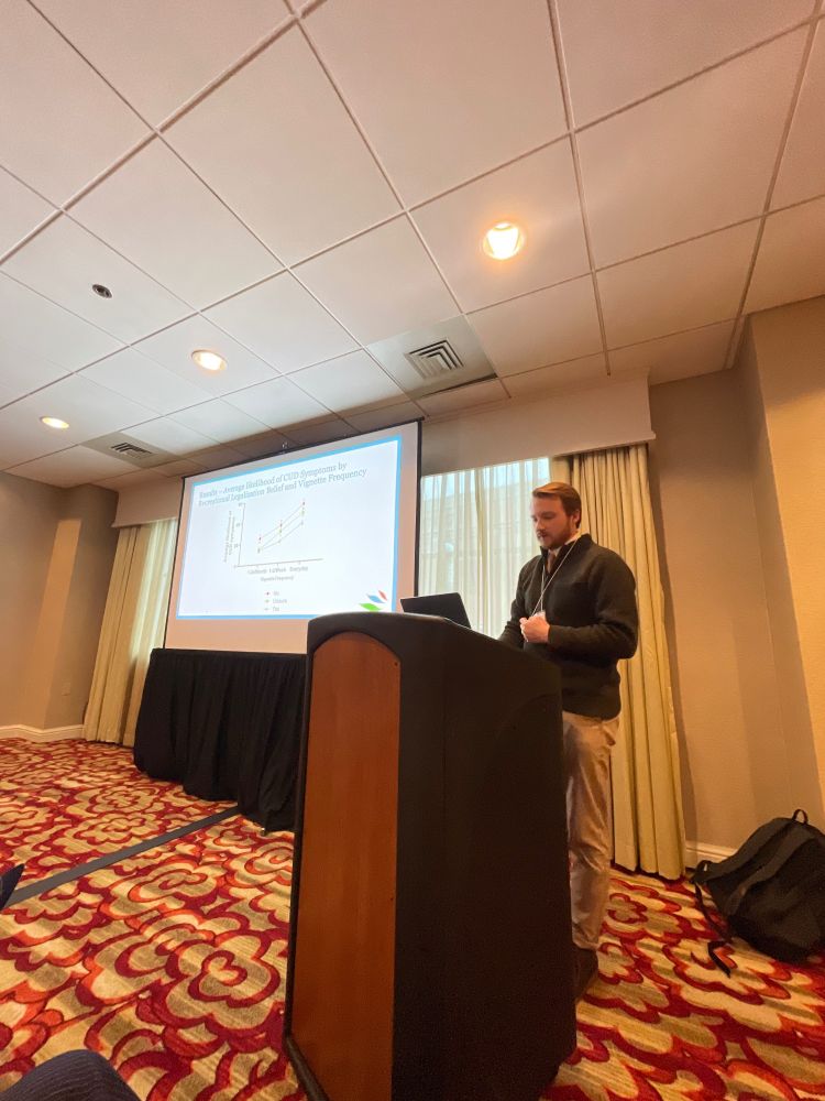 Sam Acuff presenting in front of a podium with slides in the background