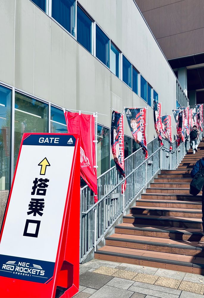 会場の入り口前の階段。手すりに各選手の幟が立てられていて、階段の前には「搭乗口」という看板がある。チーム名のレッドロケッツに因んで搭乗と表現している。