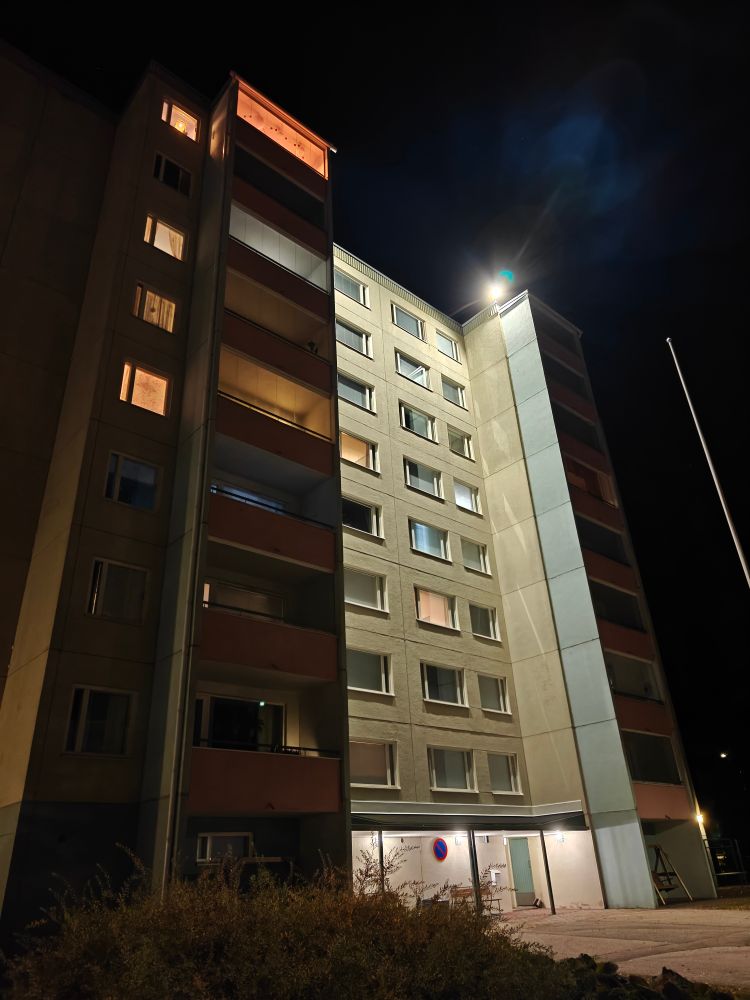 A photo of a Soviet style apartment block at night.