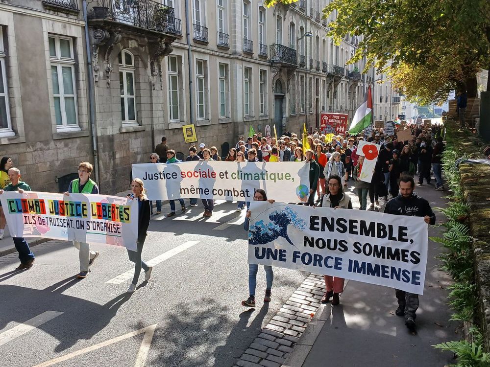 groupe de personnes portant des banderoles sur le climat, la justice et la liberté. 