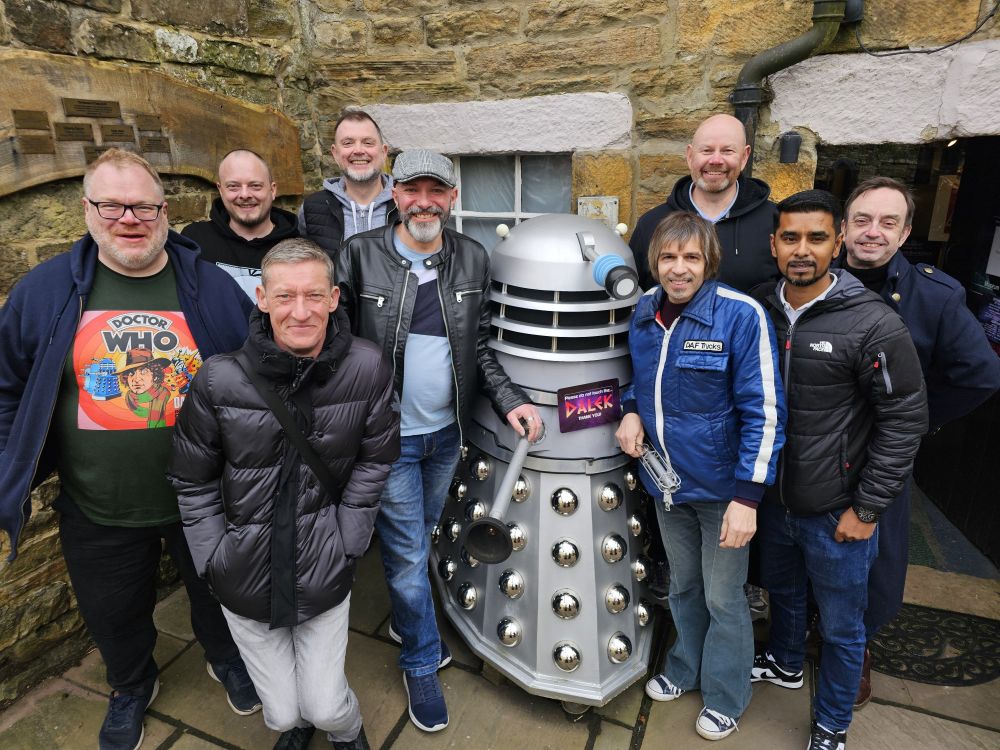 A picture of myself and 8 of my friends stood around a Dalek outside The Museum of Classic Sci-Fi.