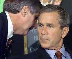 George Bush jr being whispered something from staff
