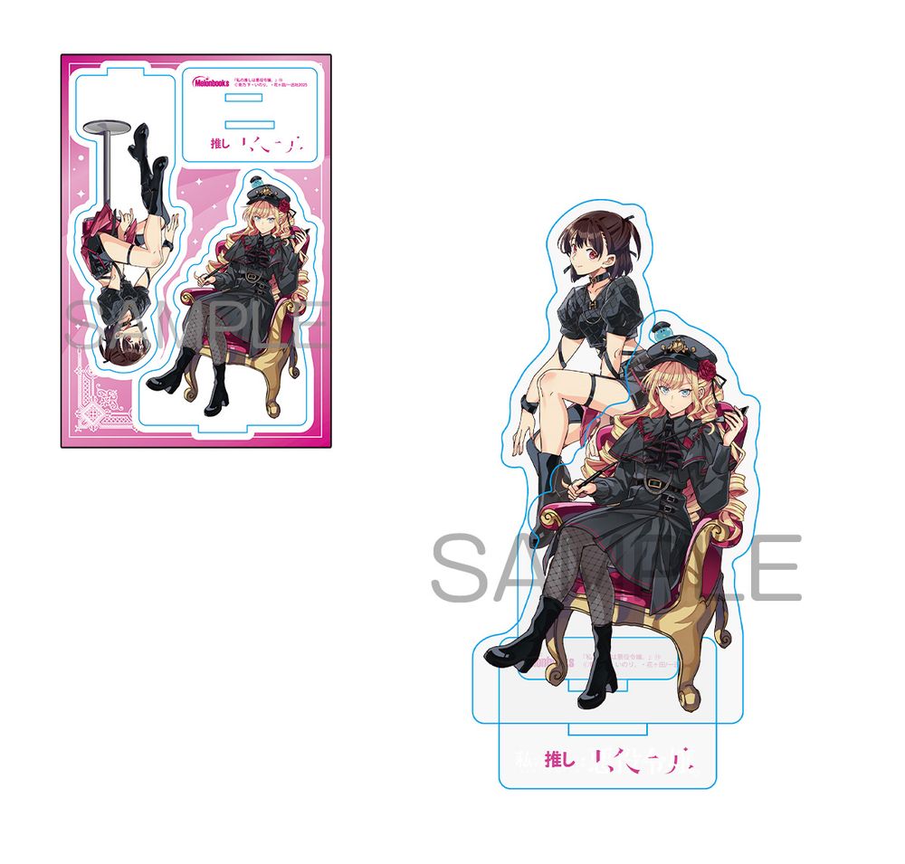 photo of acrylic standee showing Rae and Claire in “gothic lolita” / BDSM outfits. Rae is in a skimpy top and shorts with tall boots and leather bands around her arms and legs, and Claire is in a frilly black dress with red accents and fishnet stockings, holding a riding crop. Relaire is on top of Claire’s head in a black military/Tom of Finland style hat. 