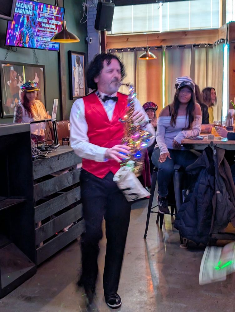 Man in a nautical outfit playing a saxophone coveted in lights, in a bar