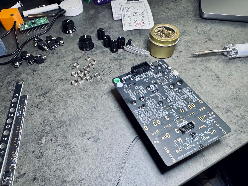 Back side of partially assembled Castor & Pollux synth module, with remaining parts scattered about