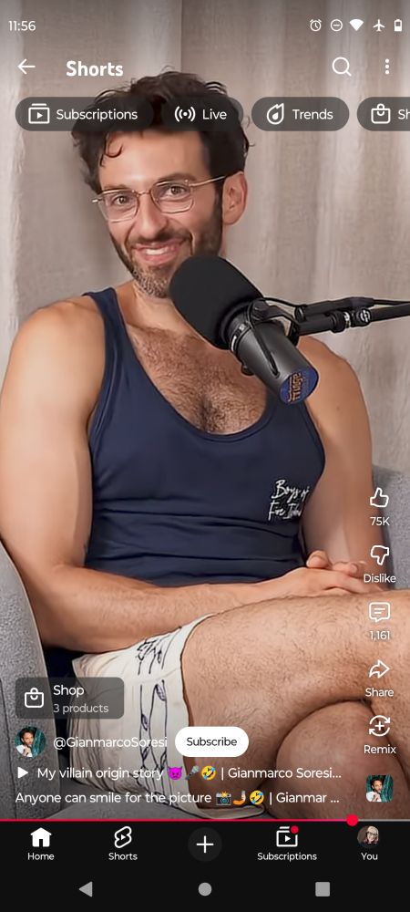 print do gianmarco soresi num corte de podcast.  ele tá de shorts e regata meio justa, pernas cruzadas, as mãos entrelaçadas e sorrindo pra câmera com a cabeça meio virada pro lado
