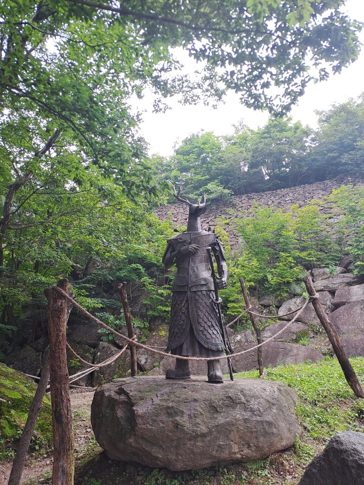 Un hybride mi-humain, mi-cerf, monte la garde, armé et protégé d'une cuirasse.