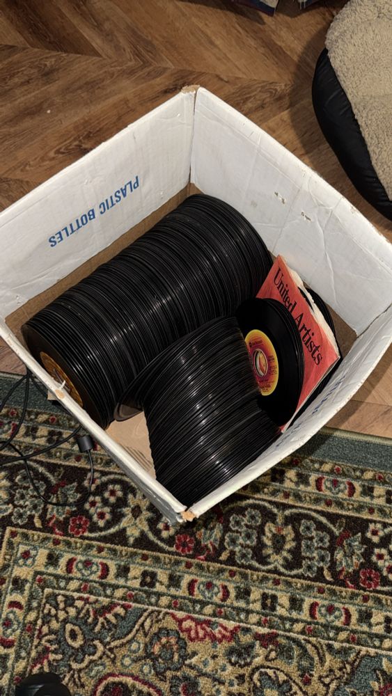 A cardboard box full of 45s