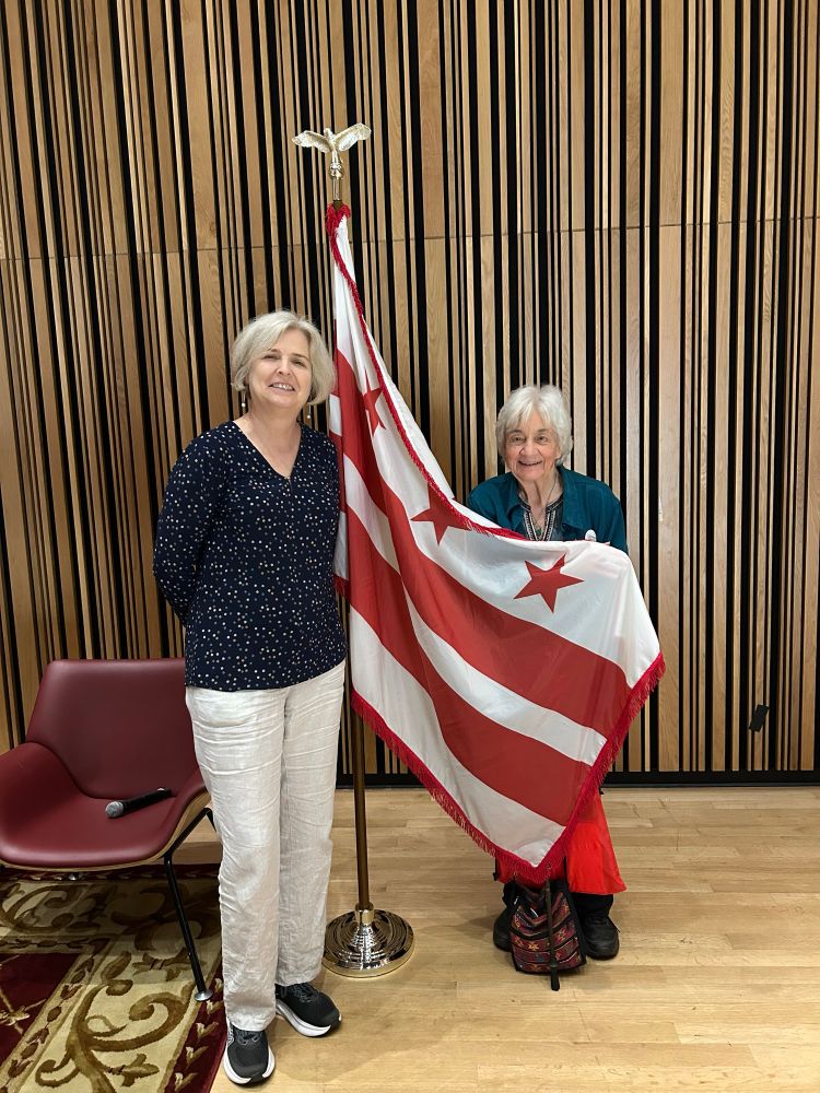 Two women standing with the DC flag.