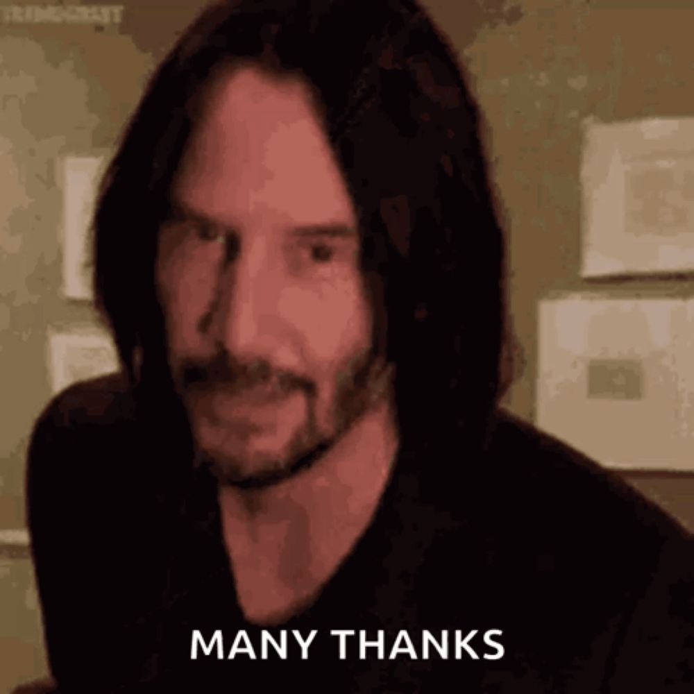 a man with long hair and a beard is giving a thumbs up and saying `` many thanks '' .