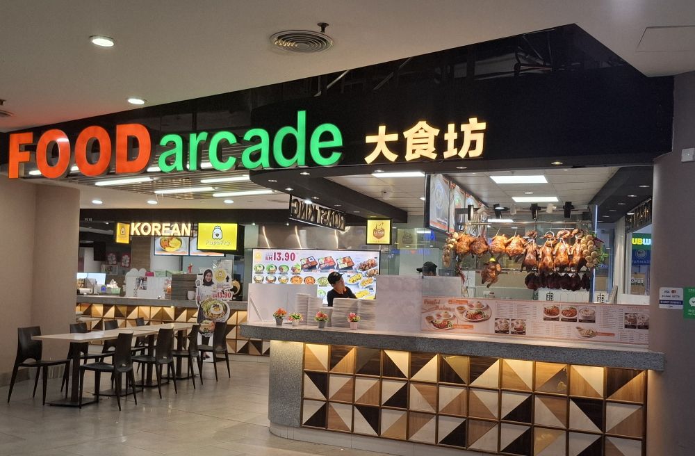 Food arcade 大食坊　という看板がついたフードコート。中国の鶏丸焼きが吊り下げられていたり、Koreanと書かれた韓国風フライドチキン屋らしき店があったり。