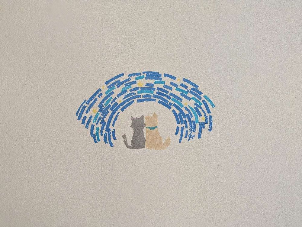 This is a drawing that features a dark brown cat with a bandaged tail and a golden-colored dog wearing a teal bandana sitting next to each other underneath a starry sky that's been broken up into a curved arch above and around the figures.