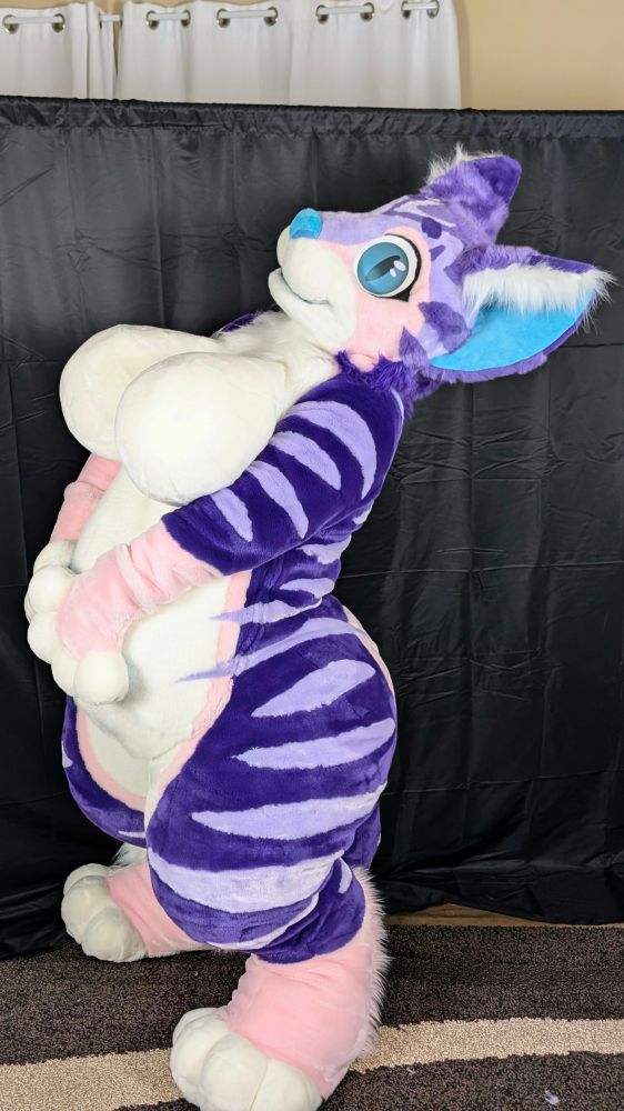 Cat fursuit leaning backwards with paws on belly