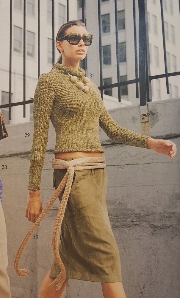 A picture of a woman in a knit sweater and belt from a knitting pattern magazine