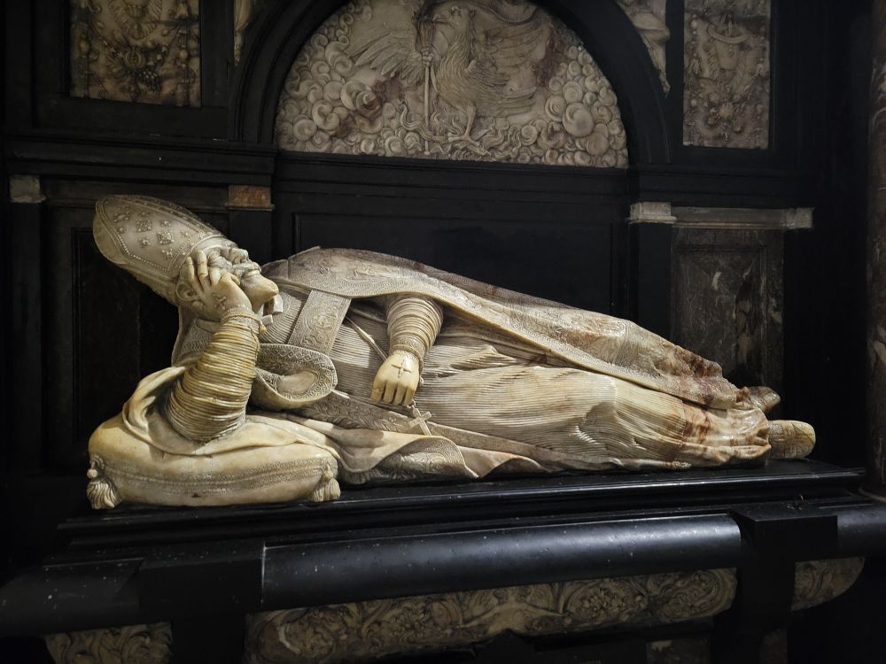 Marble statue of a clergyman laying down
