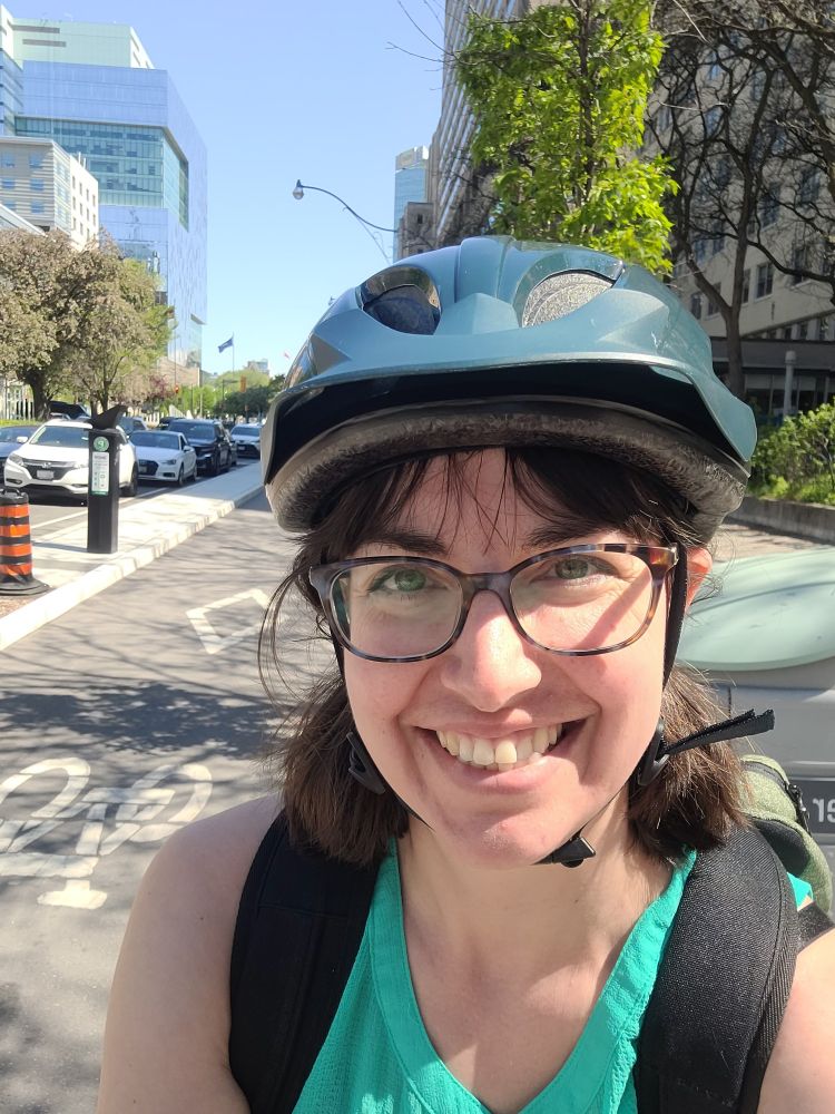 A selfie of me wearing a bike helmet stopped in the University Ave bike lane