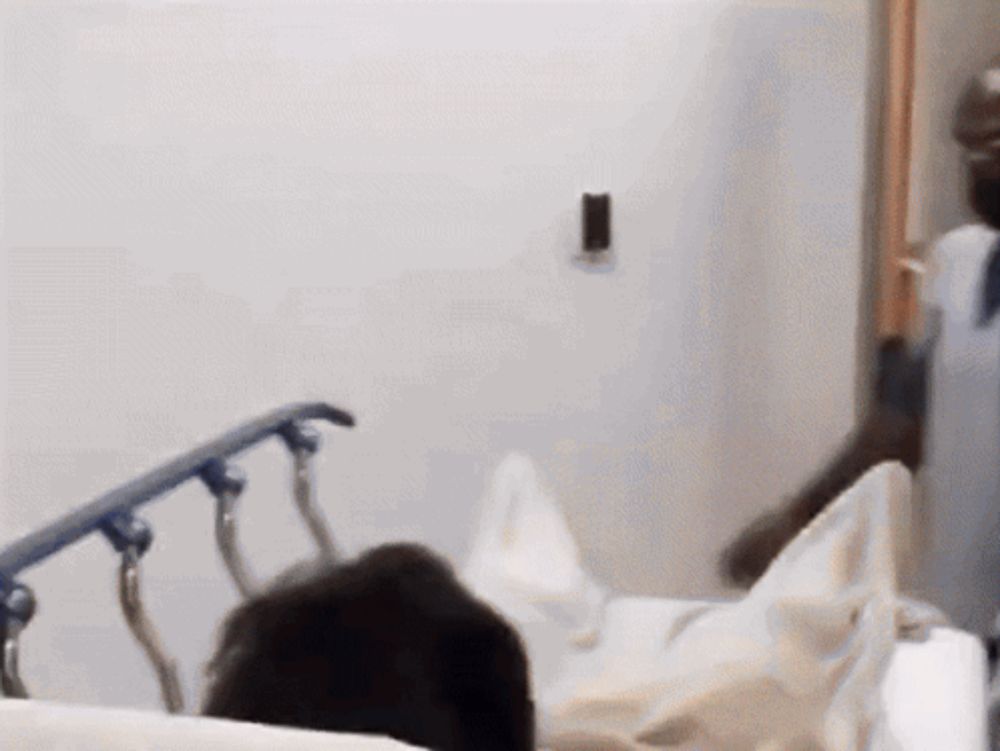 a person laying in a hospital bed with a white blanket on