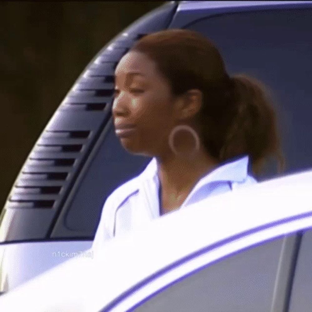 a woman wearing hoop earrings is looking out the window of a car with the word nick on the bottom