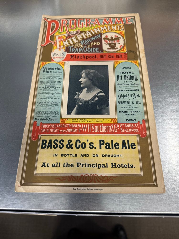 Cover of a guide to Blackpool with gold print and illuminated title in red and blue at the top of the page reading Programme of entertainments, railway and tram guide.