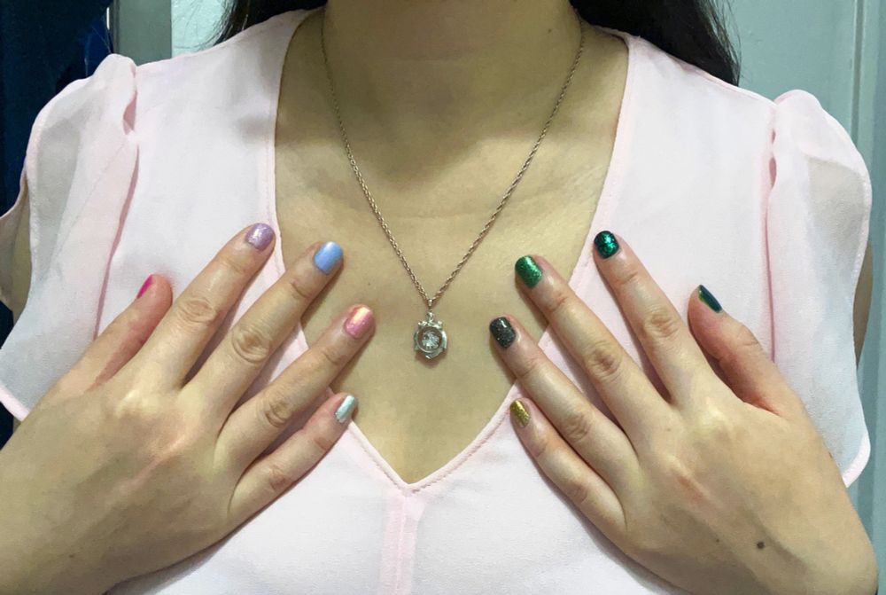 OK so most of y’all don’t care about nails or little details, but I do and this is my page, so I’m posting it! This is a closeup of my outfit showing a silver goat necklace (for Dr. Dillamond) and different nail polishes on all ten fingers—Elphaba colours on my left hand and Glinda colours on my right.