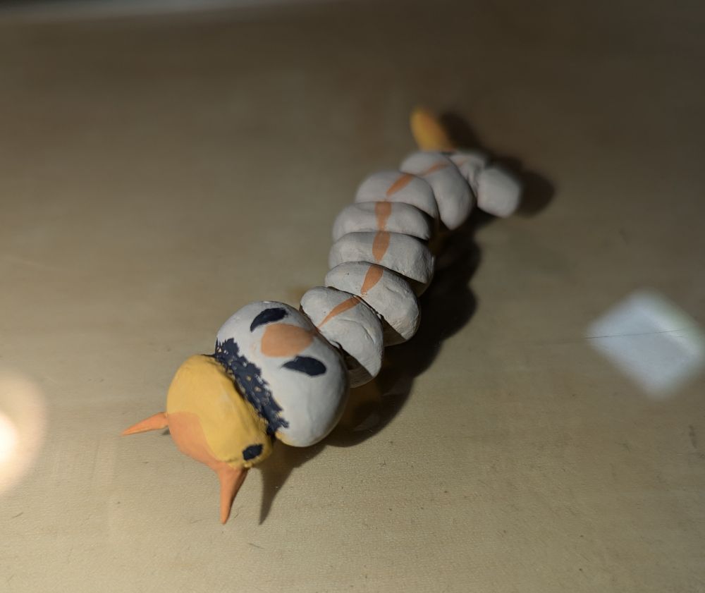 photo of a small clay sculpture of a mosquito larva