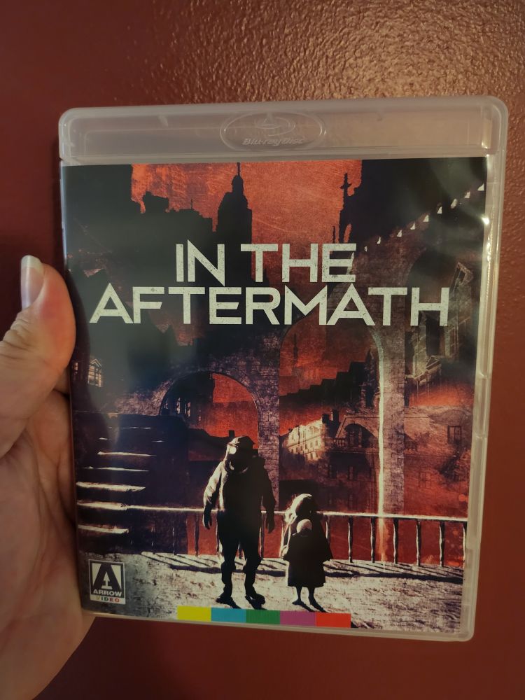 A Blu-ray copy of the movie In The Aftermath, plus my thumb and part of my hand