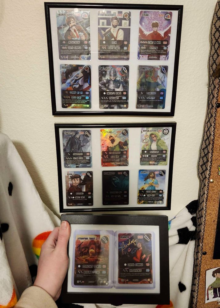 two mid size frams with 6 rare hermitcraft tcg cards each, and the one small frame with two rare signed cards