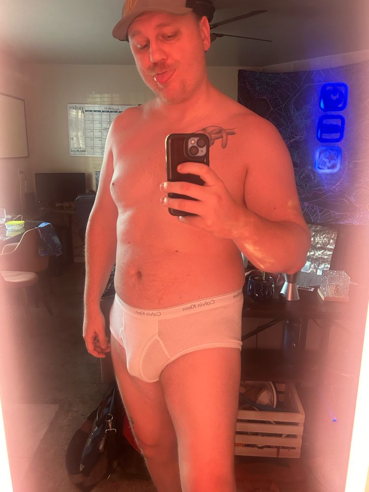 White dude wearing a baseball cap and tighty whities.