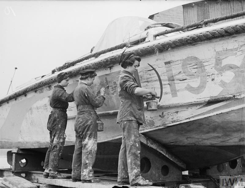 Three women painting a damaged vessel. © IWM A 19496