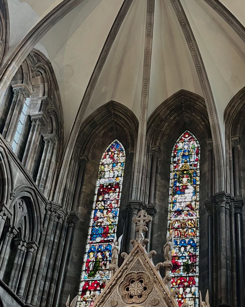 A view looking upwards at the top part of the high altar of St Mary’s Episcopal Cathedral, Edinburgh, the stained glass windows behind it, and the vaults above. 